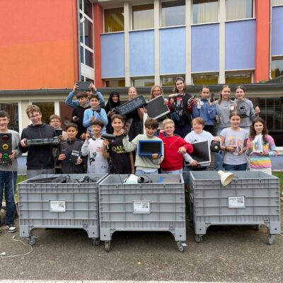 Die Klasse 7d hinter den schon halb mit Elektroschrott gefüllten Sammelbehältern