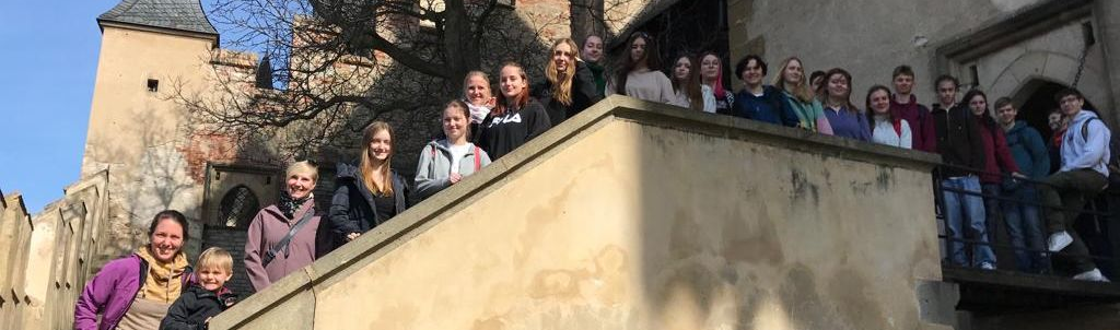 Eine Schülergruppe auf einer Treppe der Burg Karlstein bei Prag