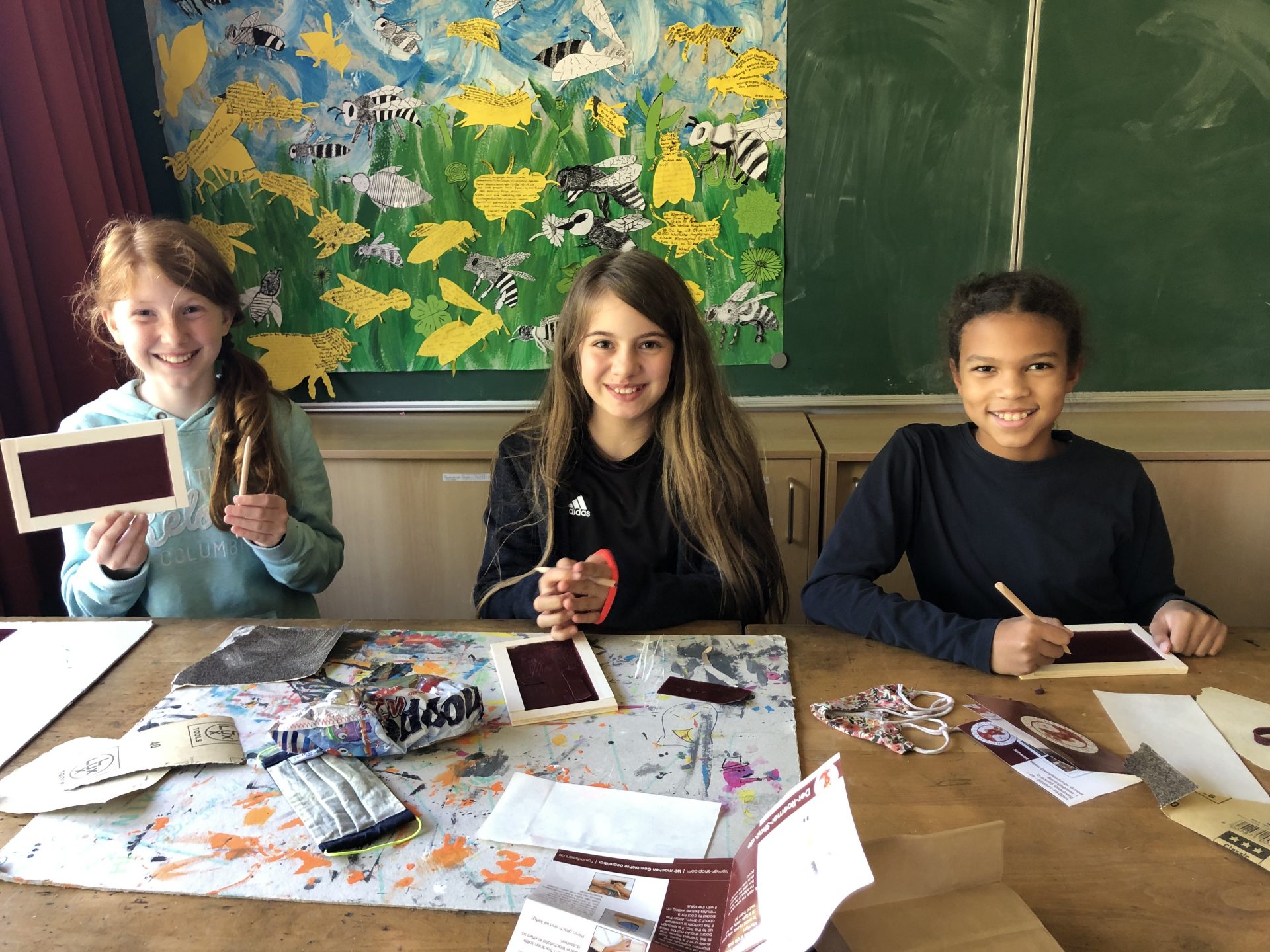 Drei Schülerinnen mit Wachstäfelchen